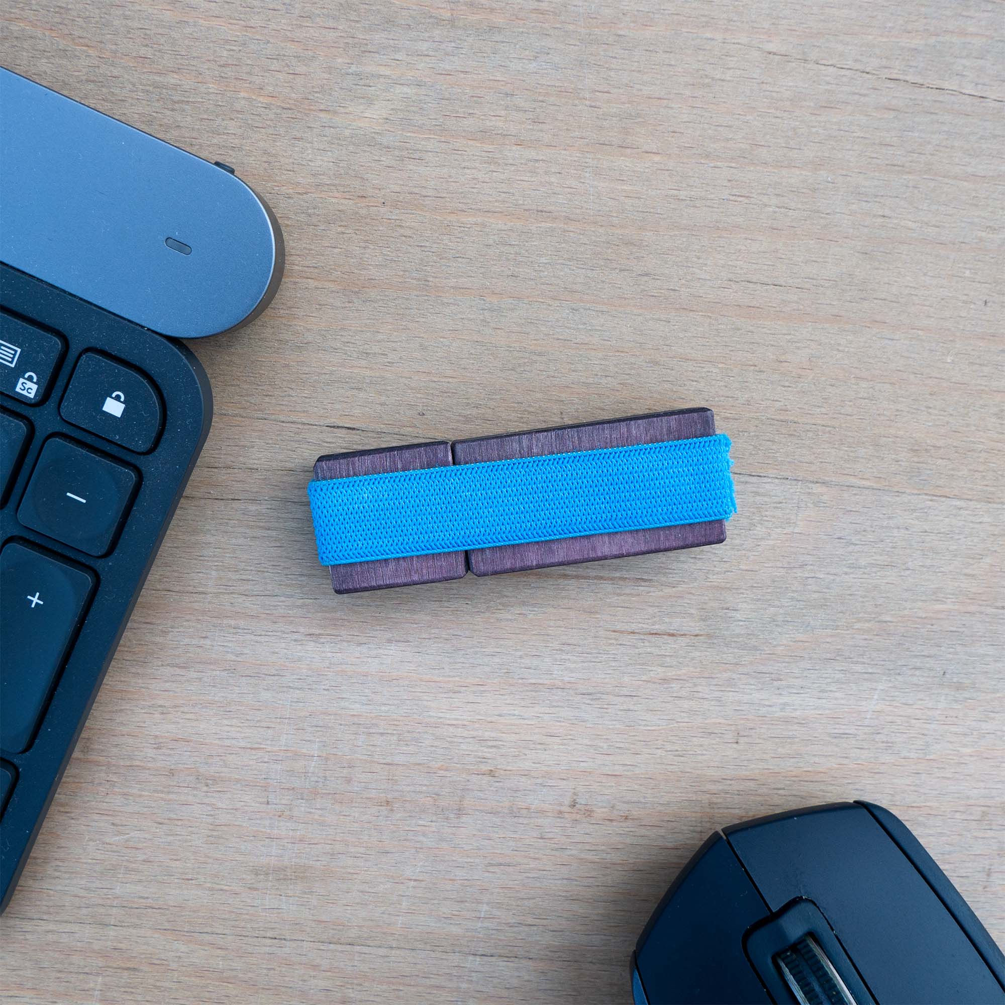 USB-Stick aus dunklem Holz, Draufsicht, Blaues Gummiband als Halterung des Deckels zum Stick